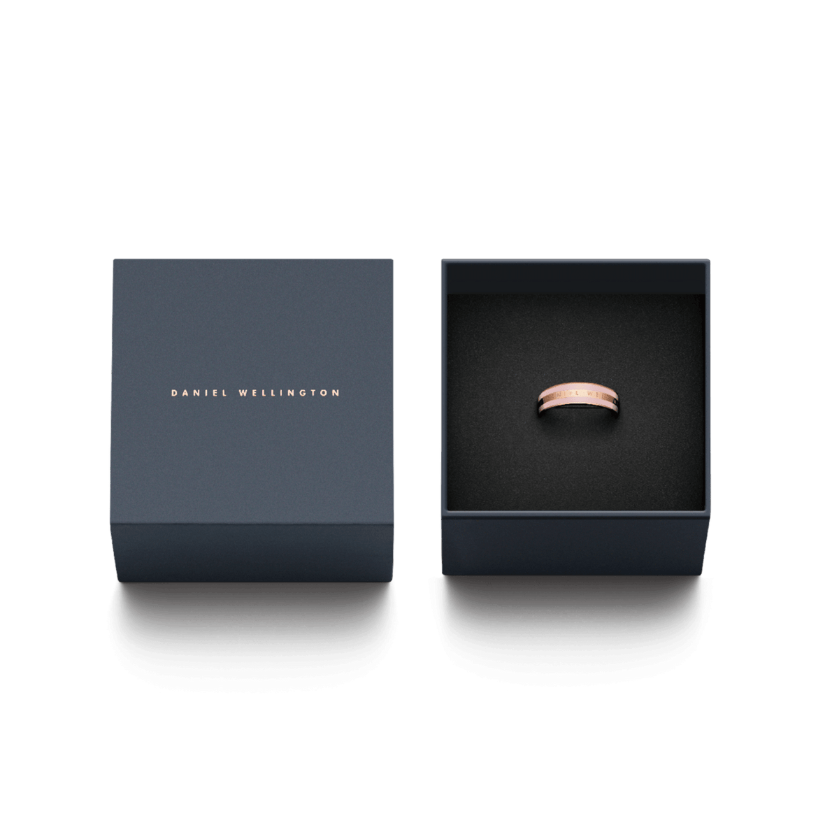 Emalie Ring Cherry Blossomが、ダークネイビーのDaniel Wellington専用ギフトボックスに収められています。蓋にはローズゴールドのブランドロゴが箔押しされ、黒いクッションの上に桜色エナメルのリングが丁寧にセットされております。