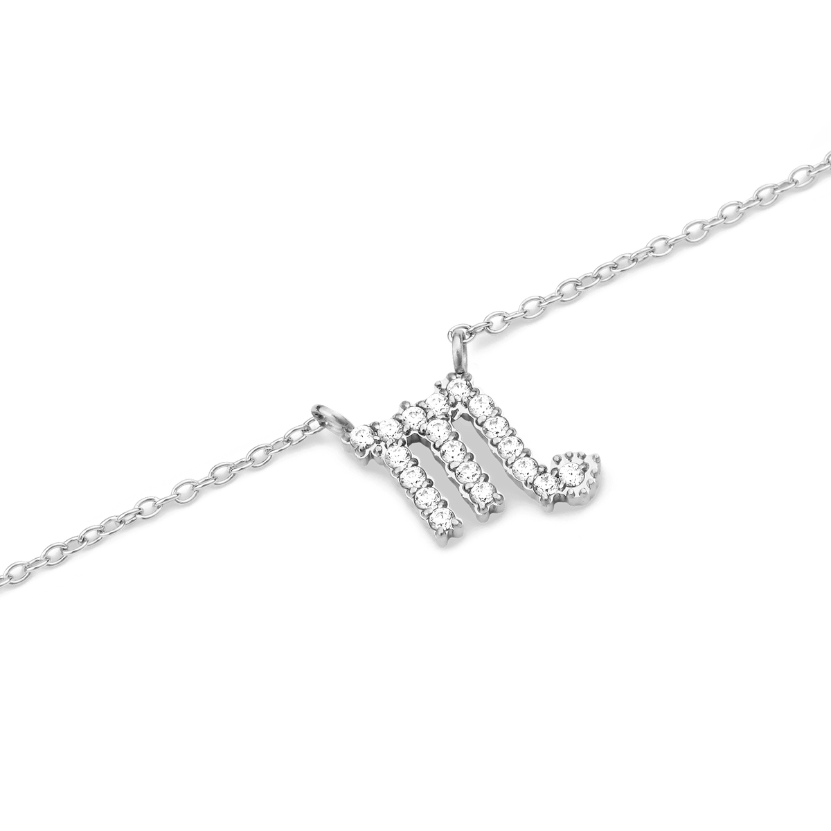 さそり座をモチーフにしたCrystal Zodiac Chain Necklace Silverのペンダント部分を斜めから撮影したクローズアップ画像です。3本の縦ラインと先端のカーブで表現されたさそり座のシンボルに沿って、クリスタルが爪留めされています。シルバーチェーンとともに白い背景に映えるデザインです。