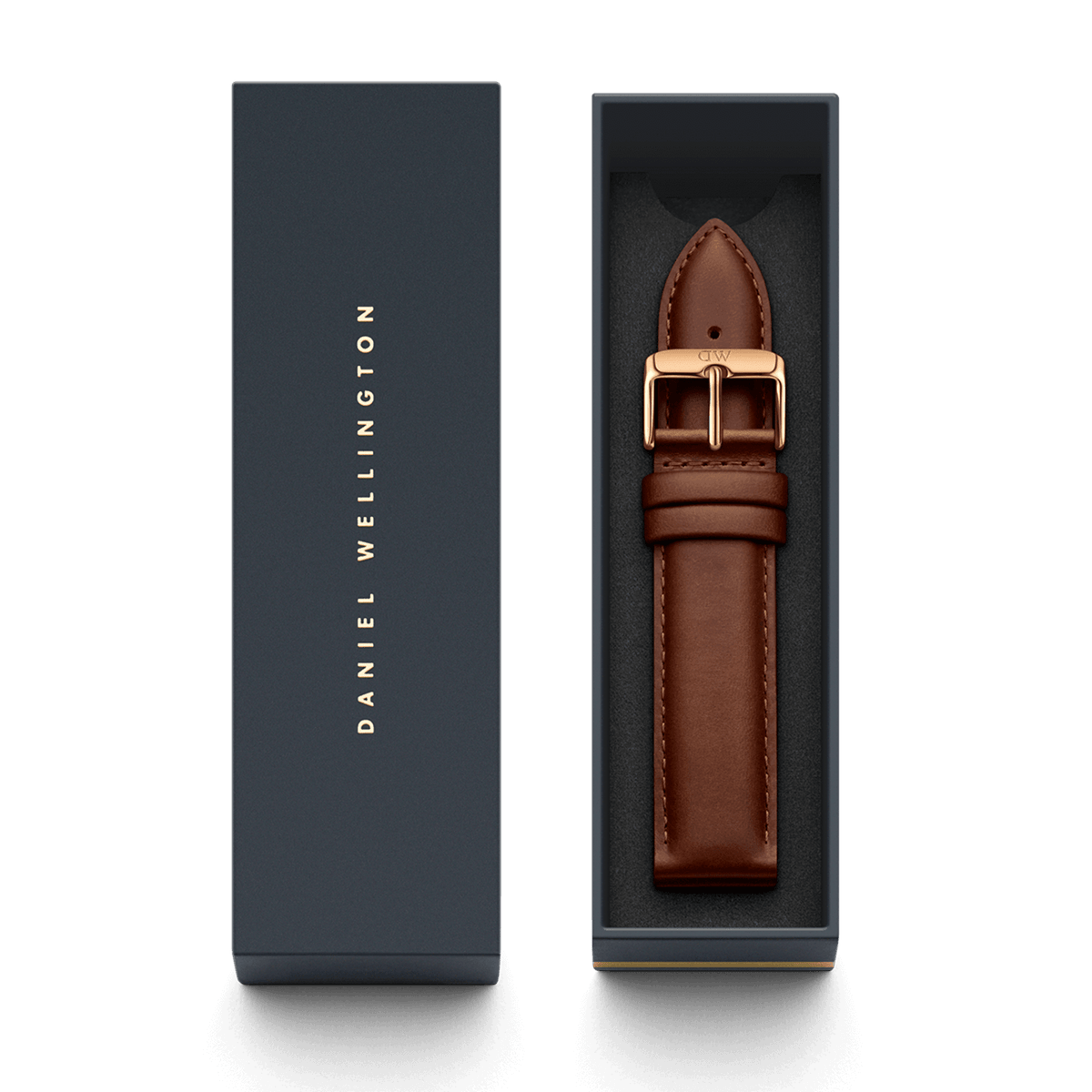 St Mawes XL ローズゴールドにブラウンレザーストラップを組み合わせ、ダークネイビーの専用ボックスに収めた状態です。ボックスの蓋にはDaniel Wellingtonのロゴがゴールドであしらわれており、ギフトにも最適な上品なパッケージとなっています。