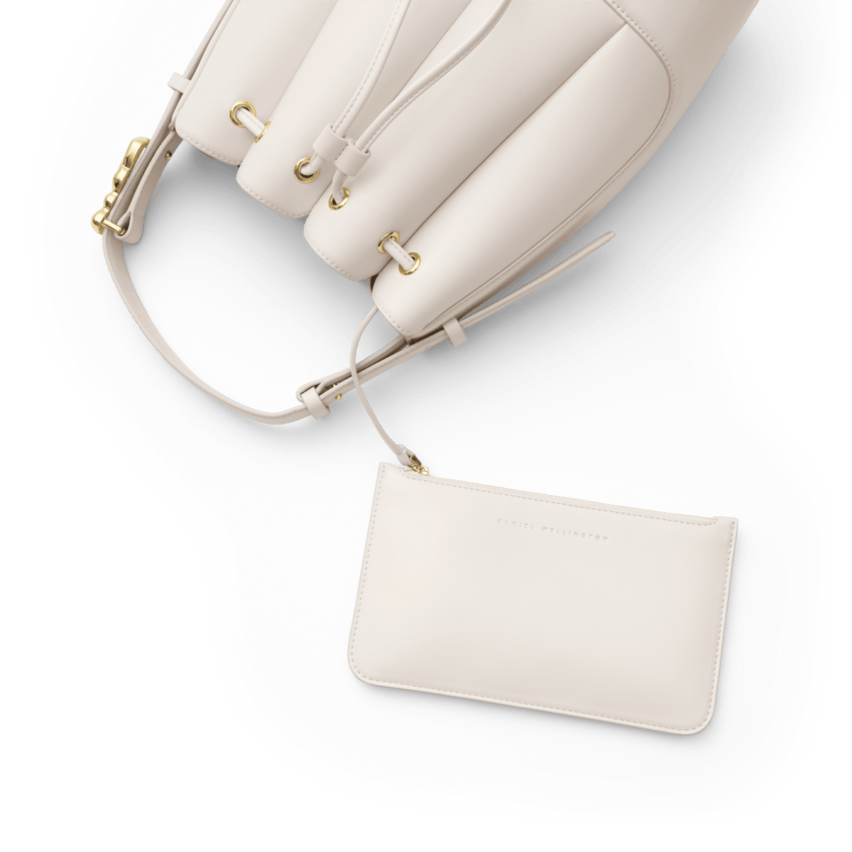 Lewis Bag Crèmeに付属のDaniel Wellingtonロゴ入りポーチのクローズアップ画像です。ドローストリングでバッグ本体と連結されており、ゴールドのハトメやクリーム色エコレザーのなめらかな質感が白い背景に映えています。