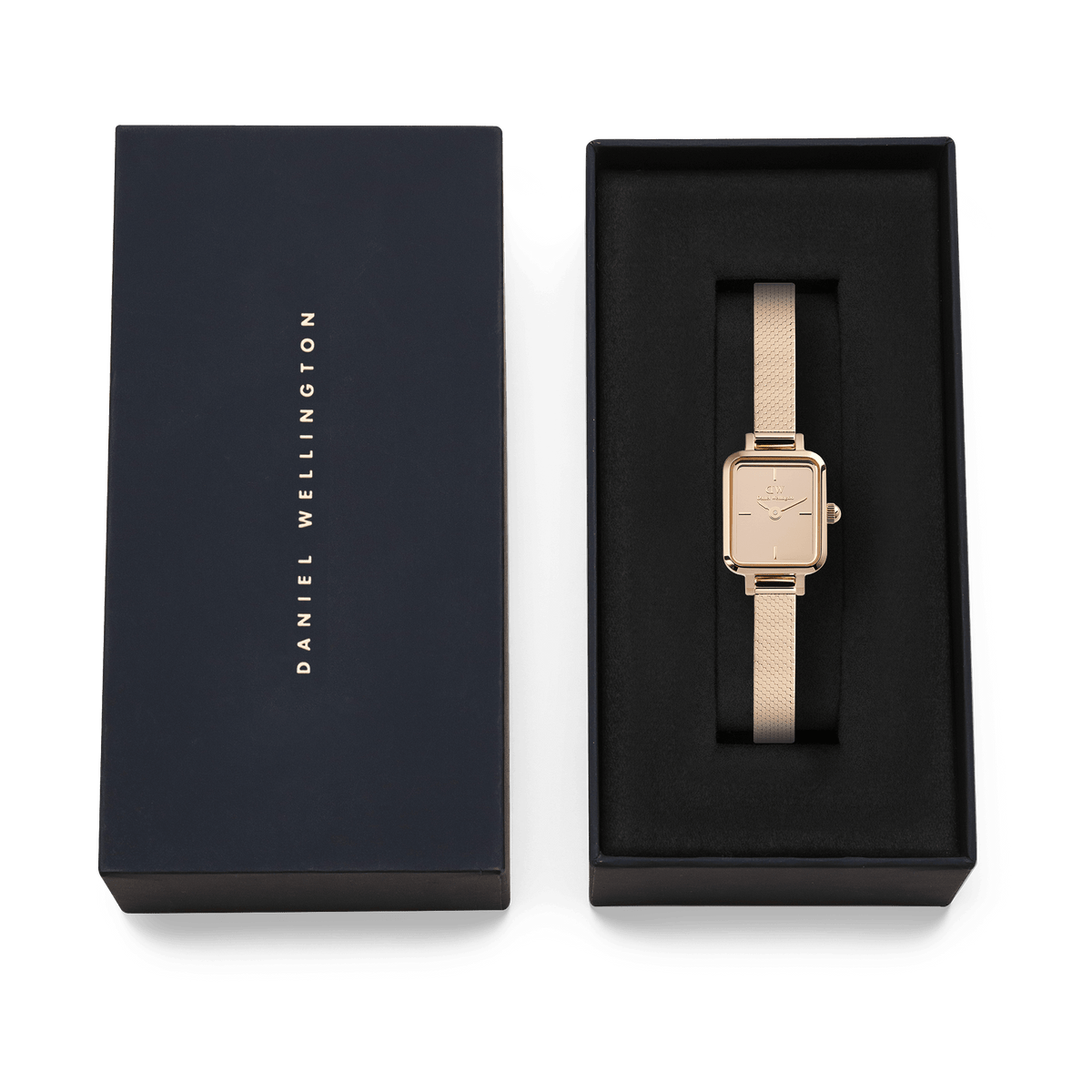 Daniel WellingtonのQuadro Mini Reflection Rose Goldは、ネイビーのブランドロゴ入りギフトボックスに収められています。黒いクッションケースの上に、ローズゴールドのミラーダイヤルとメッシュストラップが映える、贈り物にぴったりの上品なパッケージです。