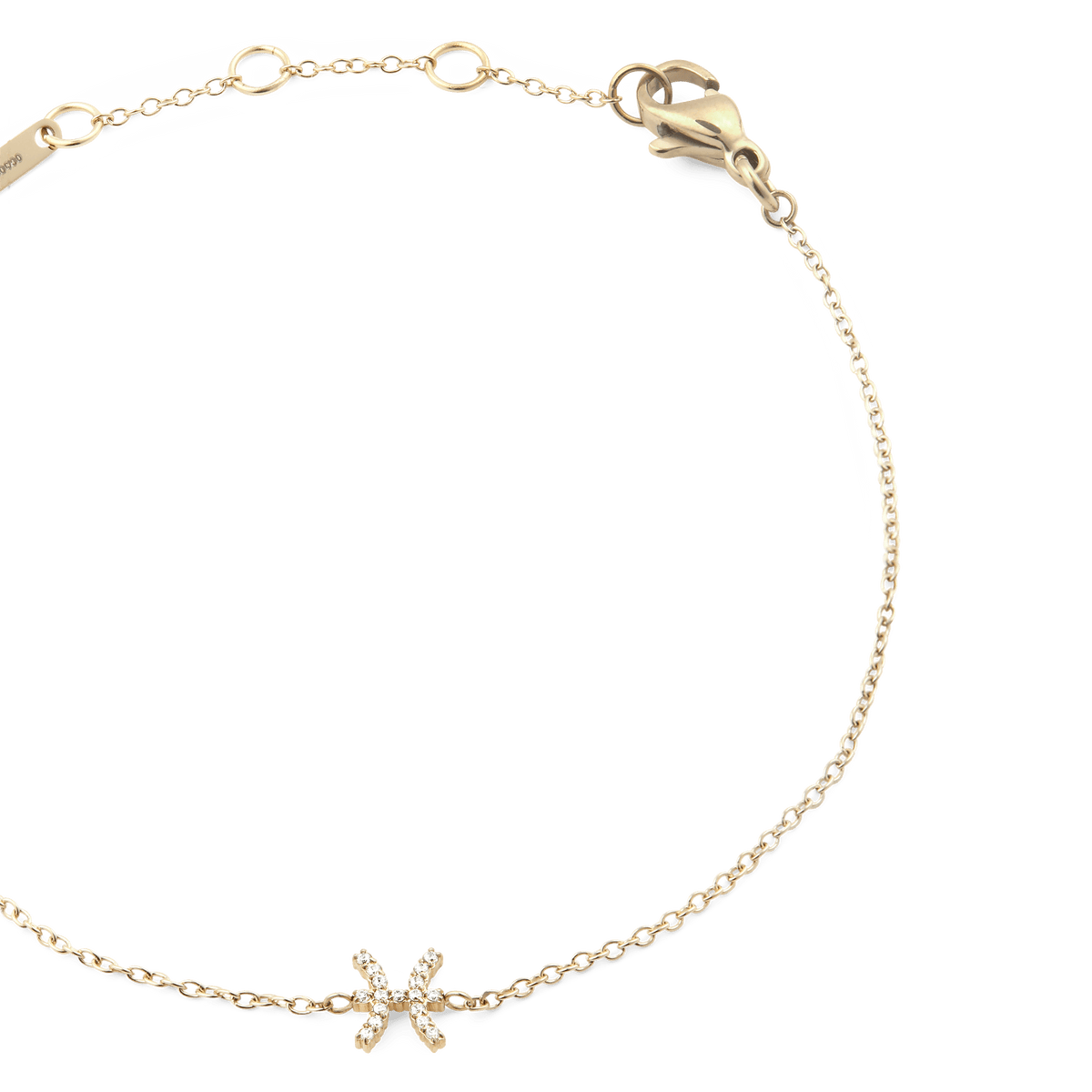クリスタル Zodiac Chain Bracelet Goldの魚座モデルを斜めから撮影したクローズアップ画像です。ゴールドのチェーンに沿って、クリスタルの魚座モチーフが繊細に輝いています。右上にはロブスタークラスプ、左上にはブランド刻印プレートとアジャスターリングが確認できます。