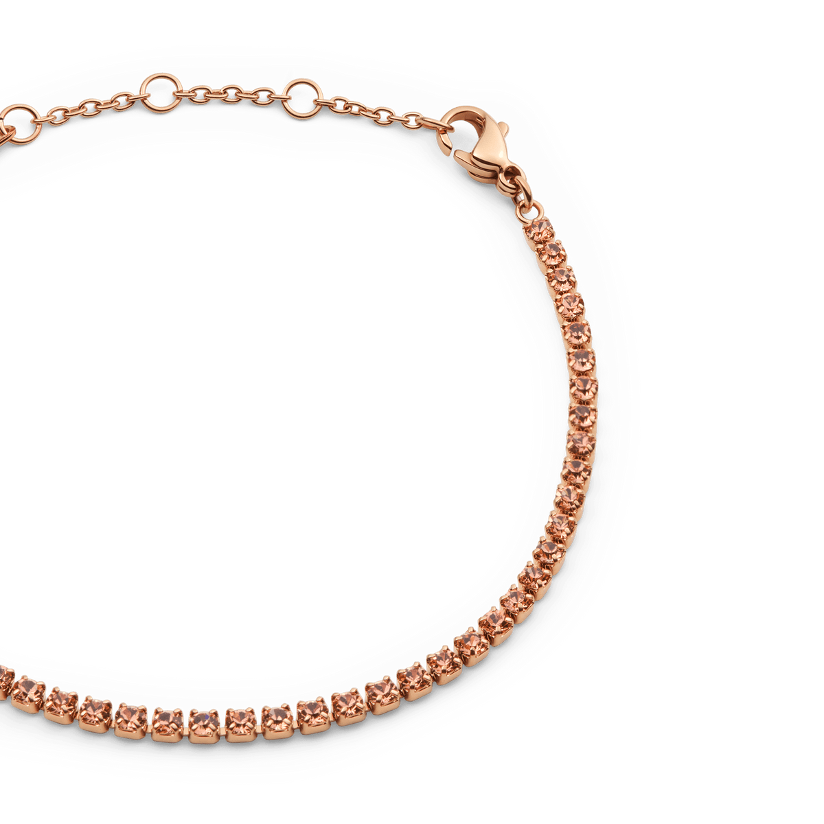アプリコットカラーのプレシオサ・クリスタルが爪留めされた、Classic Tennis Bracelet Apricot Rose Goldのクローズアップです。ローズゴールドのチェーンがロブスタークラスプからサイズ調節リングへと続き、細部まで美しく仕上げられています。