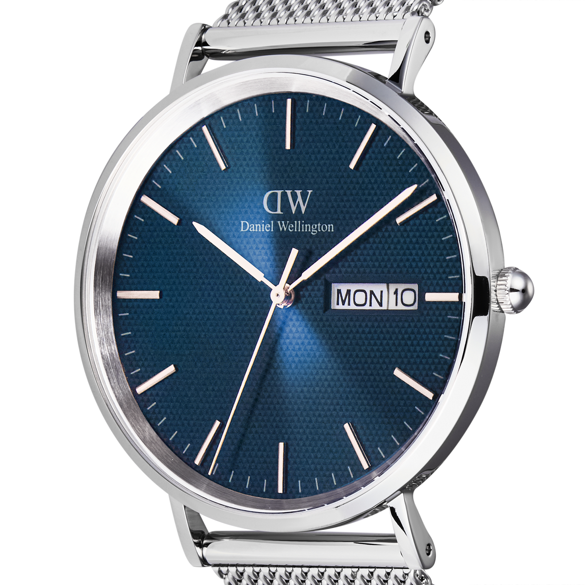 Classic Day Display Sterling Arcticの文字盤をクローズアップした画像です。ブルーの文字盤に広がる半透明のトライアングルパターンの質感や、シルバーのバーインデックス、3時位置に配されたデイデイト窓が鮮明に捉えられています。また、ポリッシュとブラッシュ仕上げが交差するケースの陰影も際立っています。
