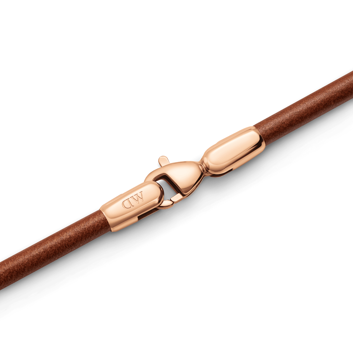St Mawes Bracelet Rose Goldのクラスプ部分を拡大したディテール画像です。ローズゴールドのロブスタークラスプにはDaniel Wellingtonのロゴが刻印されており、ブラウンレザーコードとの接合部まで丁寧に仕上げられた質感がわかります。