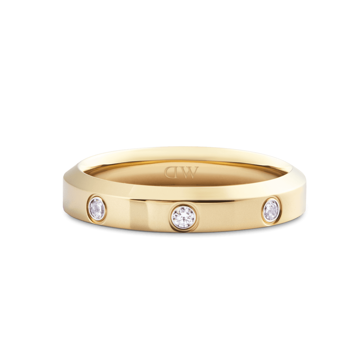 Classic Lumine Ring Gold 4 mmを斜め上から撮影したクローズアップ画像です。フラットなゴールドバンドに3つのキュービックジルコニアが埋め込まれ、リングの内側にはDaniel Wellingtonのロゴが刻印されています。