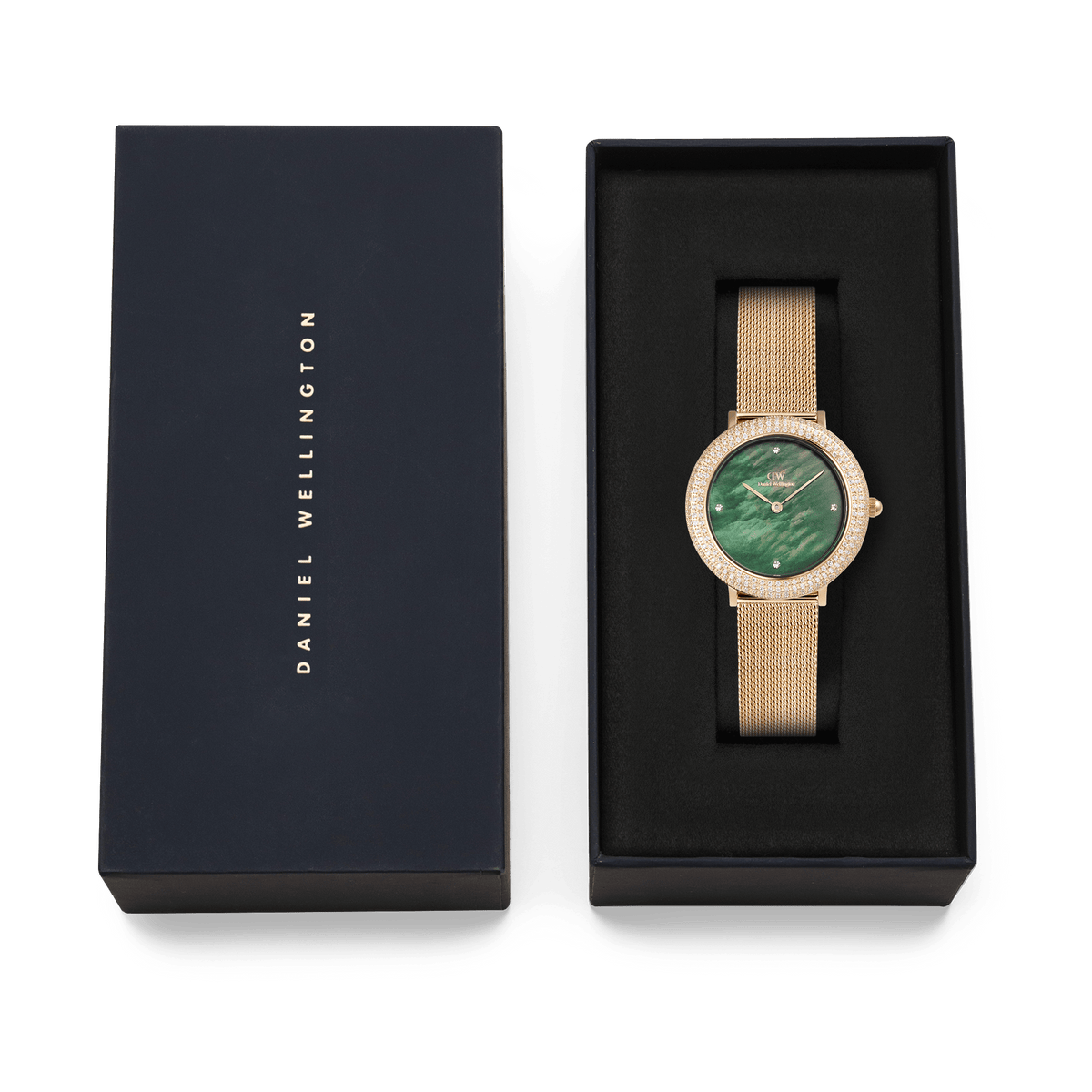 ダニエルウェリントンのブランドロゴがあしらわれたネイビーカラーのギフトボックスに収められたCrystalline Bezel Evergold Green。ブラックのクッショニング上に、ゴールドメッシュストラップとグリーンのマザーオブパールダイヤルが美しく映え、贈り物にぴったりの上質なパッケージです。