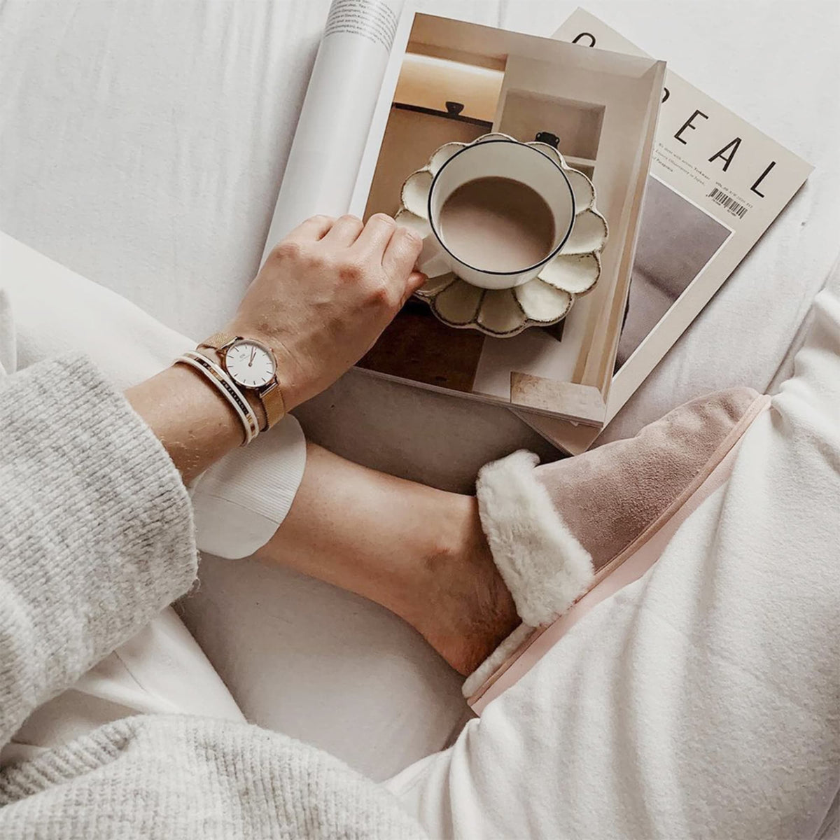 Emalie Bracelet Satin White Rose Goldをローズゴールドのメッシュストラップ腕時計と重ねづけしたスタイル。リラックスした自宅時間に、雑誌とコーヒーを楽しみながら、手元にさりげない華やかさをプラスしています。