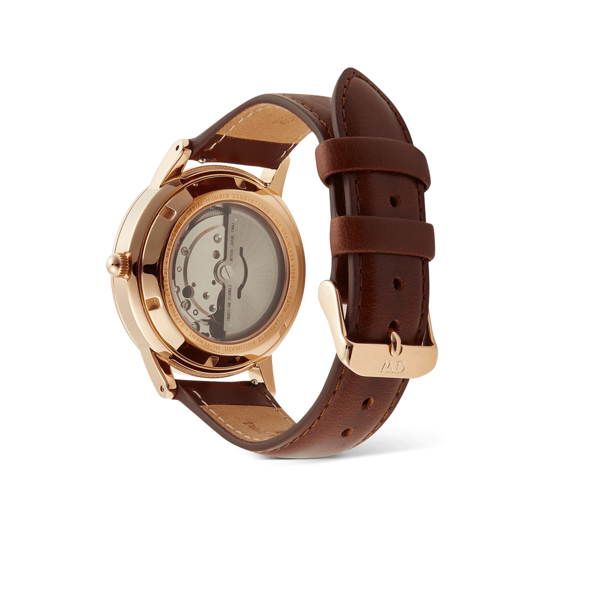Iconic St Mawes Automatic Rose Goldの裏面をご紹介する画像です。サファイアガラスのエキシビションケースバック越しに、自動巻きムーブメントのローターや歯車を確認いただけます。ローズゴールドのケースバックにはモデル名やスペックが刻印されており、ブラウンレザーストラップのローズゴールドバックルにはブランドロゴが施されています。
