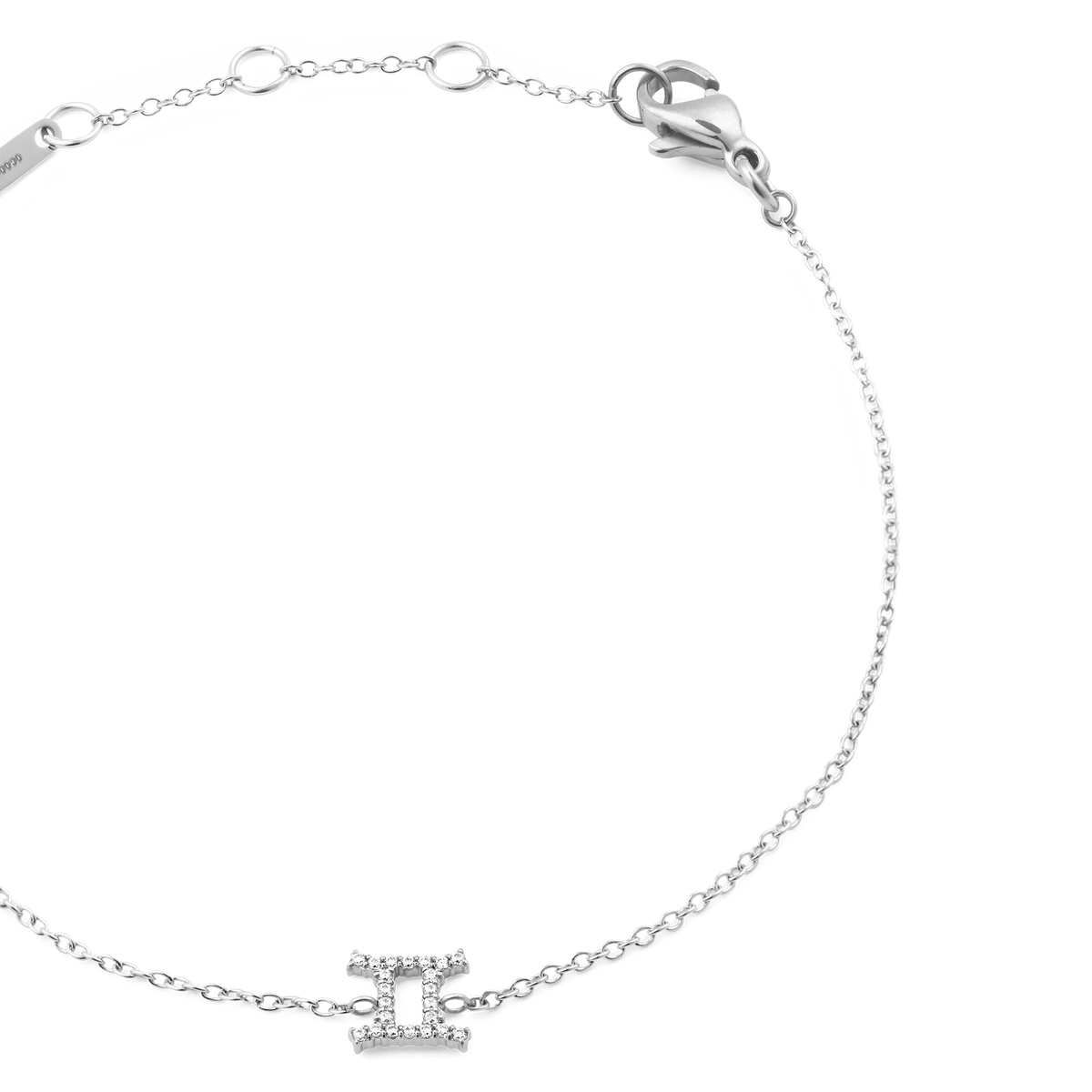 シルバーのCrystal Zodiac Chain Braceletふたご座モデルを斜め上から撮影した画像です。キュービックジルコニアがあしらわれたふたご座チャームとシルバーチェーンの質感がわかり、ロブスタークラスプやアジャスターリング、ブランドプレートも確認できます。