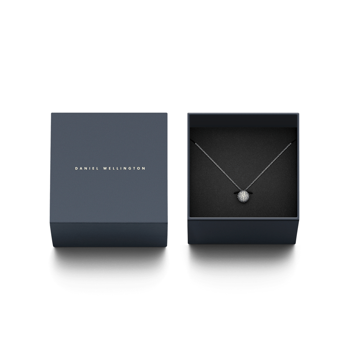 Daniel Wellingtonのブランドロゴが刻印されたネイビーのギフトボックスに収められたPavé Crystal Pendant Necklace Silver。黒いクッションの上にCZクリスタルの球体ペンダントとシルバーチェーンが美しく配置され、贈り物にぴったりの上品なパッケージングです。