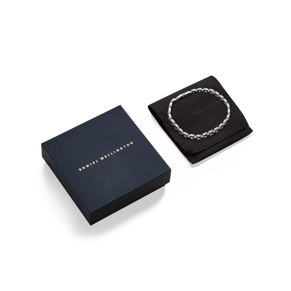 Daniel Wellingtonの3-Link Braceletシルバーとギフトパッケージ。ネイビーカラーのブランドロゴ入りボックスの横に、ブラックのジュエリーポーチが添えられ、その上にシルバーブレスレットが丁寧に収められています。贈り物にぴったりの上品な仕上がりです。