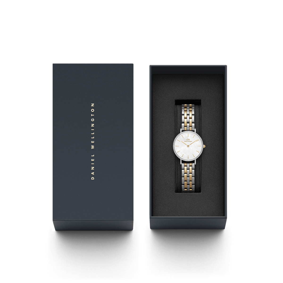 ダニエルウェリントンのPetite Lumine Bezel 5-Link Two-Tone MOPが、ネイビーのブランドギフトボックスに収められています。箱の蓋にはゴールドのブランドロゴが縦にあしらわれ、内側のブラッククッションの上には、クリスタルベゼルとツートーンブレスレットの腕時計が美しくセットされています。