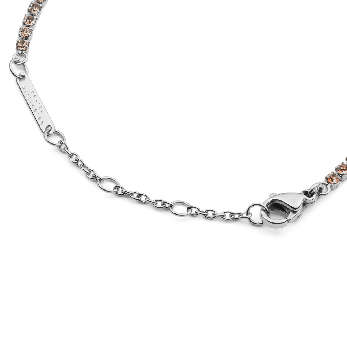 Classic Tennis Bracelet Apricot Silverのサイズ調節用チェーン部分のディテール画像です。Daniel Wellingtonの刻印が入ったブランドプレートと、スムーズに閉じるロブスタークラスプ、アジャスターチェーンの仕上がりをご確認いただけます。