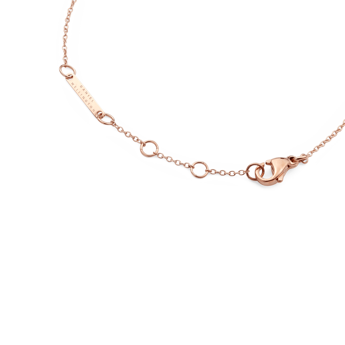 Crystal Zodiac Chain Bracelet Rose Goldのクラスプ周辺を拡大した画像です。Daniel Wellingtonの刻印が施されたローズゴールドのブランドプレートと、アジャスター用の丸カン、ロブスタークラスプの細部まで丁寧に仕上げられている様子がご覧いただけます。