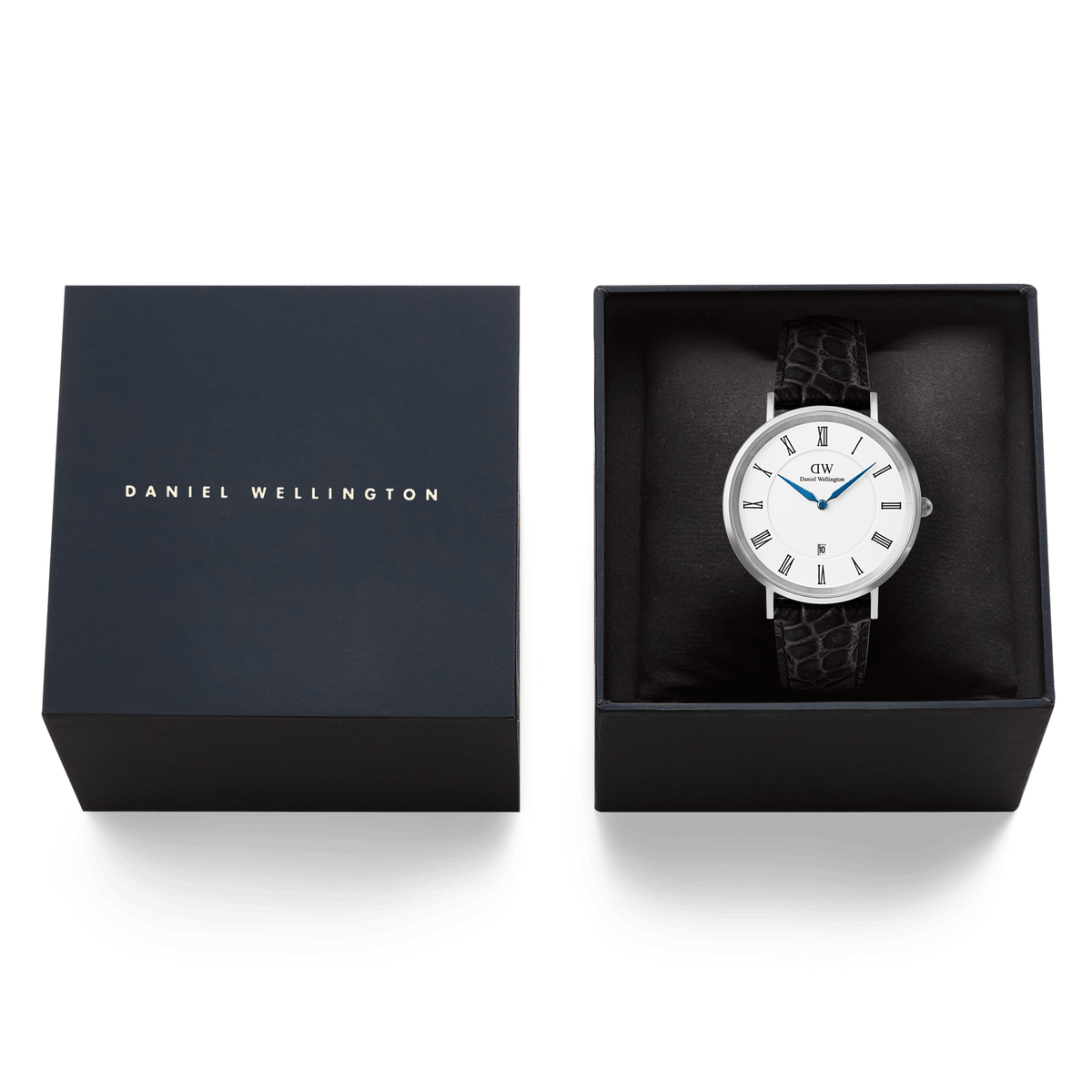 Daniel WellingtonのClassic Roman Numerals Date Black Croc Belly Silverは、ネイビーのブランドボックスに収められています。クッションの上にセットされたホワイト文字盤とブルーの針が、ギフトにも最適な上品なパッケージの中で美しく映えます。