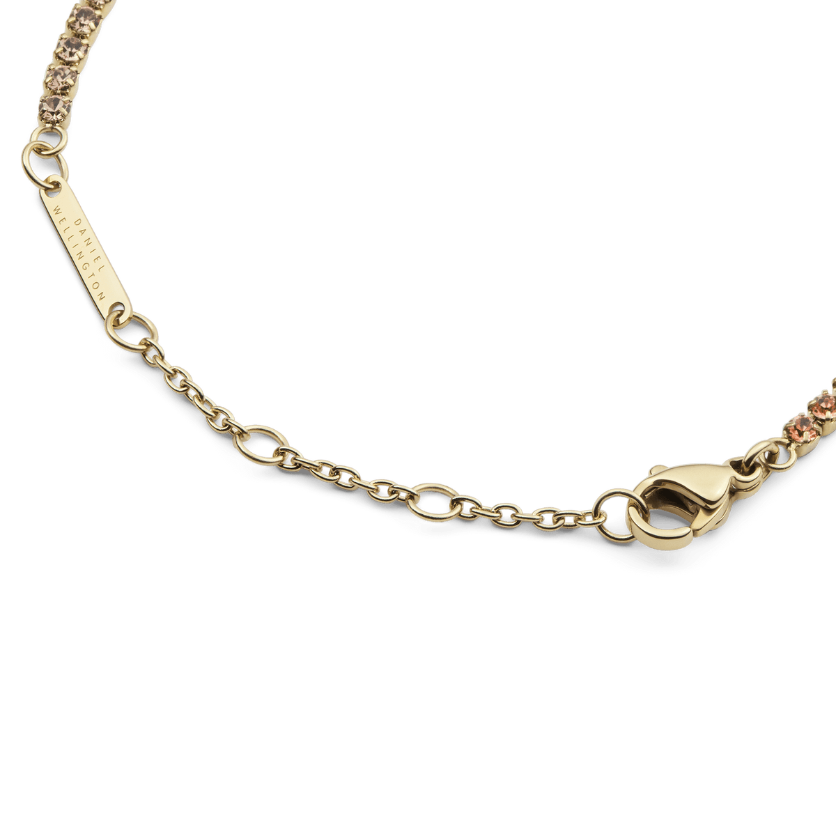 Classic Tennis Bracelet Apricot Goldのクラスプ部分のディテールです。Daniel Wellingtonの刻印が入ったゴールドのブランドプレートと、フラットに収まるロブスタークラスプ、サイズ調節用のチェーンが確認できます。