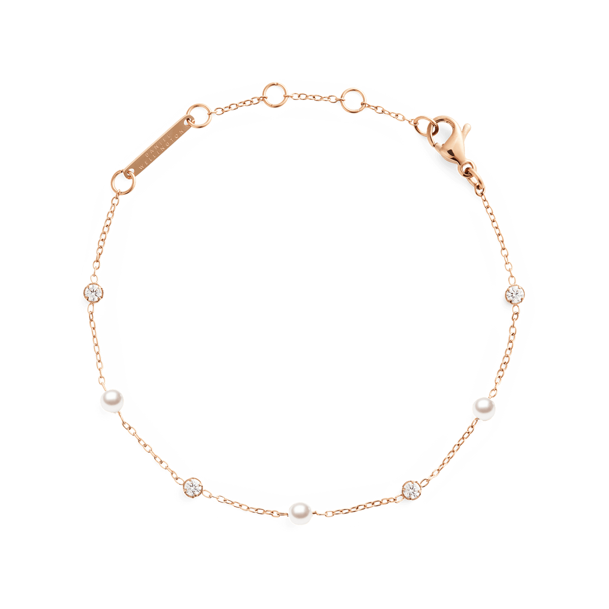 ダニエルウェリントンのPearl Bracelet Rose Gold。細いローズゴールドチェーンにパールとクリアストーンが交互にあしらわれ、ブランドロゴ入りのプレートとロブスタークラスプが付いています。