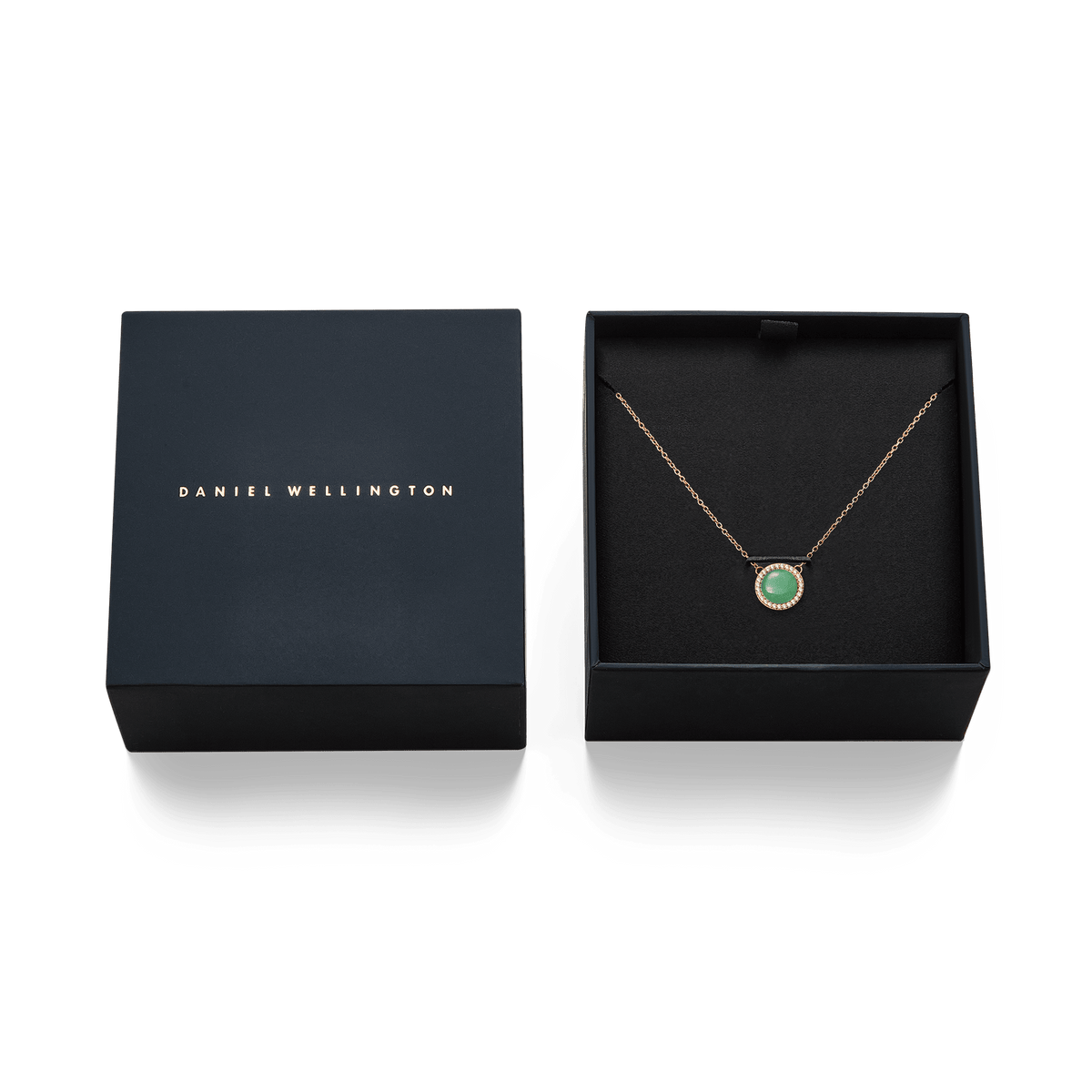 Daniel Wellingtonのブランドロゴが箔押しされたネイビーのギフトボックスに収められたAudrey Necklace Jade Rose Gold。黒いクッションケースに翡翠のペンダントとローズゴールドチェーンが丁寧にセットされ、贈り物にぴったりの上品なパッケージです。
