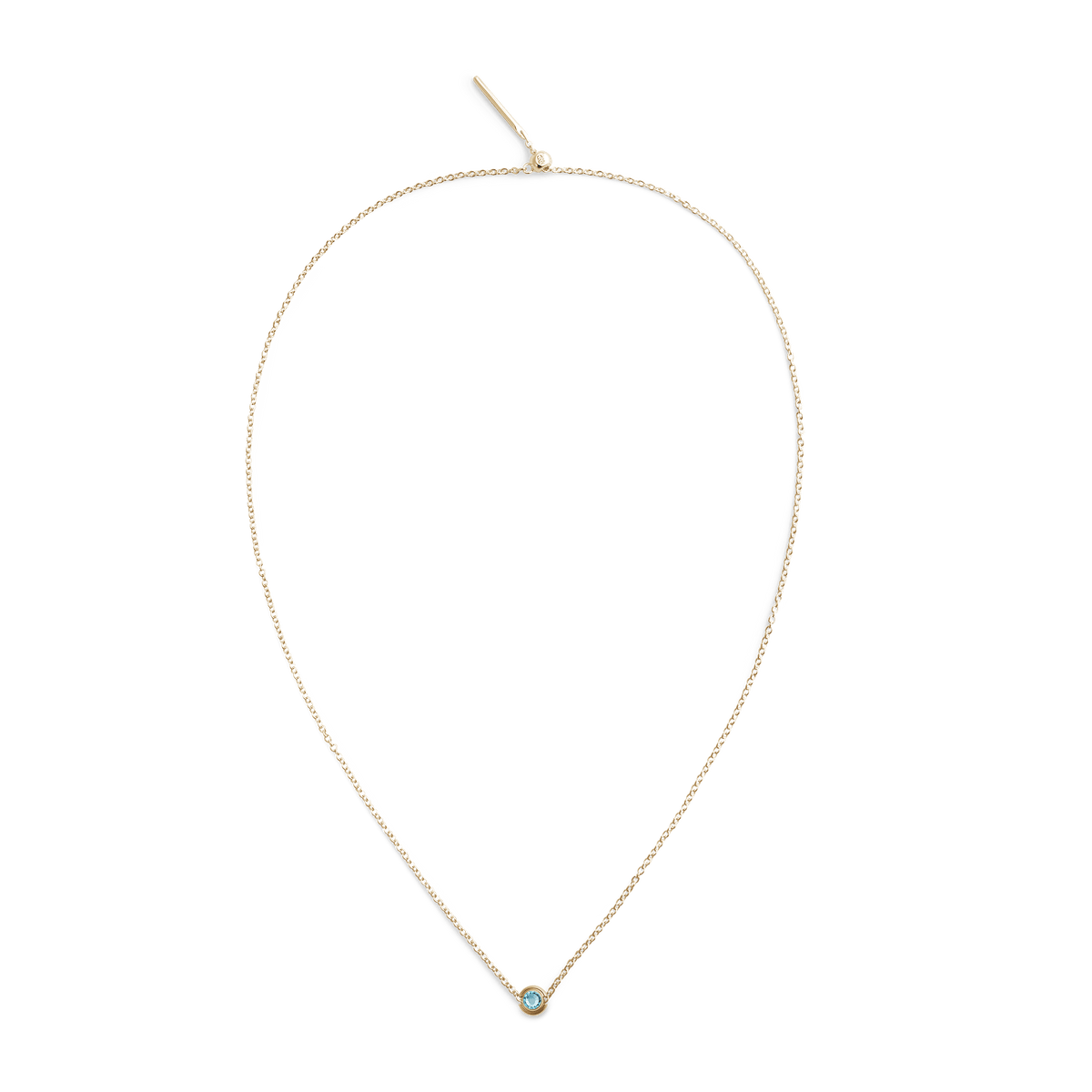 ダニエルウェリントンのDecember Charm Goldをセットしたゴールドチェーンネックレスの全体像です。細身のチェーン中央にアクアブルーのクリスタルチャームが一粒あしらわれ、ミニマルながら上品なデザインが白い背景に映えています。