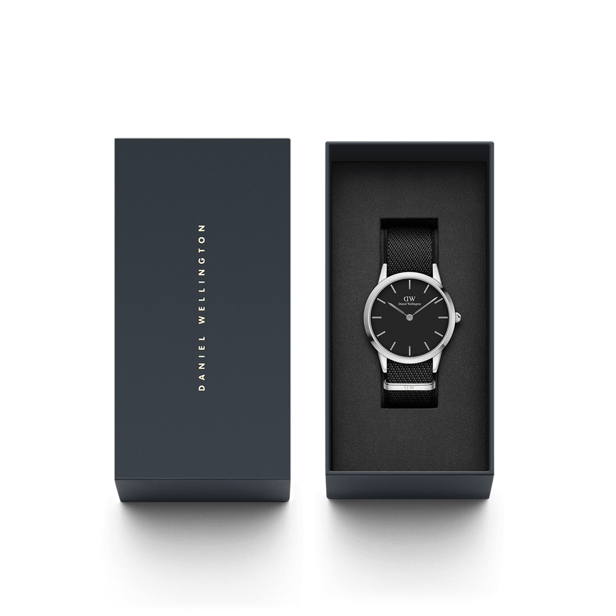 Daniel WellingtonのIconic Black NATOが、ネイビーのブランドギフトボックスに収められたパッケージ画像です。ブラックのNATOストラップとブラックダイヤルのモノトーンな佇まいが、上品なギフトボックスの中で引き立ち、贈り物にぴったりの仕上がりとなっています。