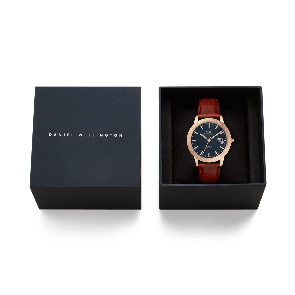 ダニエルウェリントンのアイコニックな「Iconic St Mawes Automatic Rose Gold」を、ネイビーカラーのギフトボックスに収めた贈り物に最適なセットです。ブラックの文字盤とブラウンのレザーストラップが美しく調和し、ブランドロゴ入りの蓋とともに上品な仕上がりとなっています。