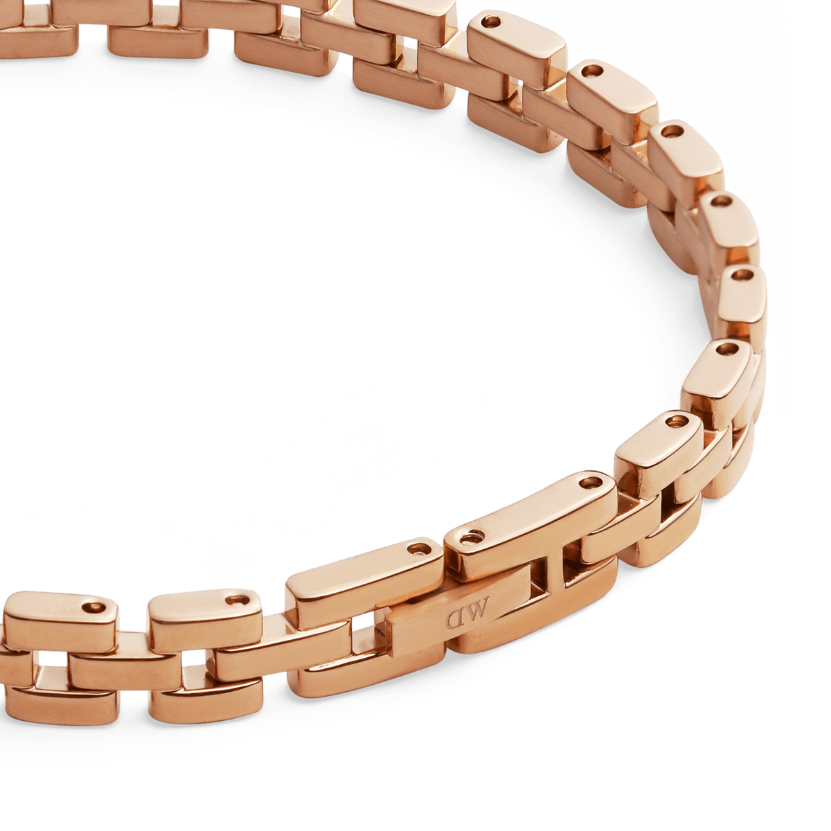 3-Link Braceletのローズゴールドクラスプ部分を斜めから捉えたディテール写真です。リンク側面に刻印されたDaniel Wellingtonのロゴと、PVD加工によるローズゴールドの上品な輝きがご覧いただけます。