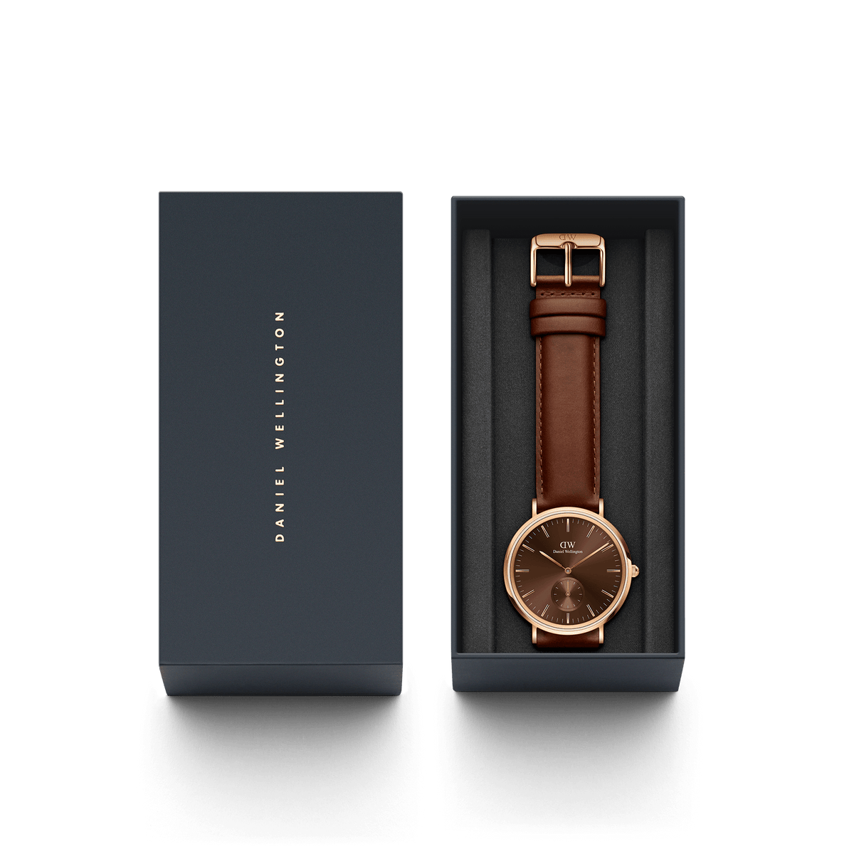 ダニエルウェリントンのギフトボックスに収められたClassic Multi-Eye St Mawes Amber Rose Gold。ネイビーのボックスにはブランドロゴが箔押しされた蓋があしらわれ、ダークブラウンのレザーストラップとアンバーカラーのダイヤルが美しく映える本体が並んでいます。パッケージ全体を上から見た画像です。