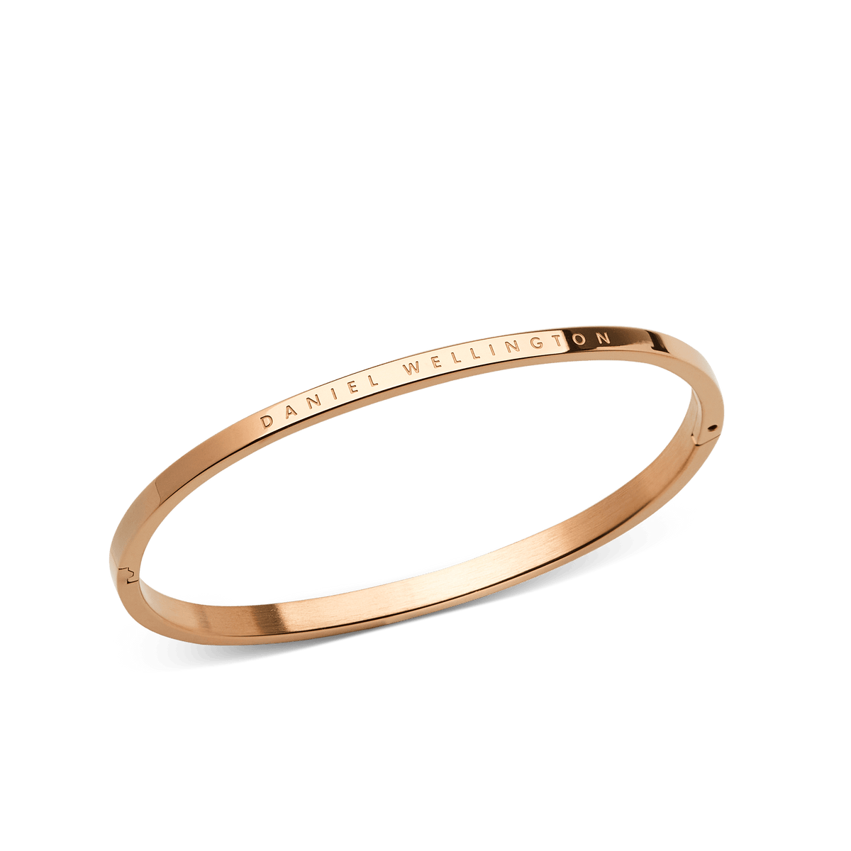 ローズゴールドのClassic Bangleを斜めから撮影した商品画像です。細身のステンレススチール製本体にはDaniel Wellingtonのロゴが刻印され、上面はサテン仕上げ、側面はポリッシュ仕上げと質感の違いが際立ちます。また、ヒンジ部分の構造もご確認いただけます。