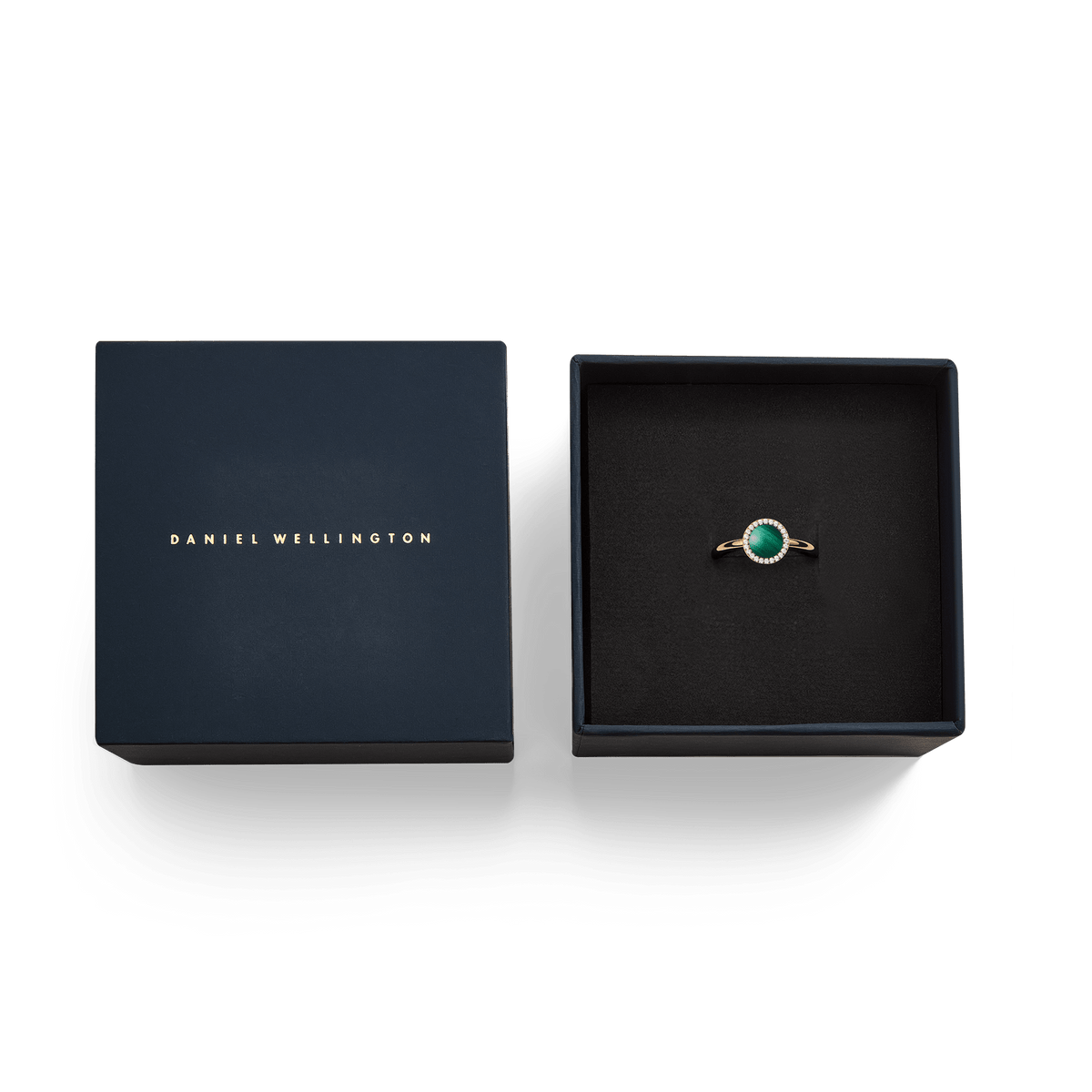 オードリーリング マラカイト ローズゴールドが、ダークネイビーのダニエルウェリントン ギフトボックスに収められた様子です。ブラックのクッションの上で、マラカイトのグリーンとローズゴールドのリングが映え、ギフトにふさわしい上品な仕上がりとなっています。