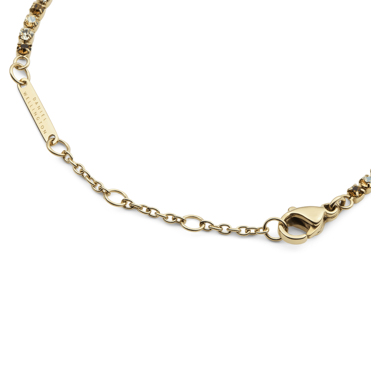 Classic Tennis Bracelet Honey Combo Goldのクラスプ周りのディテールです。Daniel Wellingtonの刻印が入ったゴールドのブランドプレート、サイズ調整用のチェーン、ロブスタークラスプが確認できます。