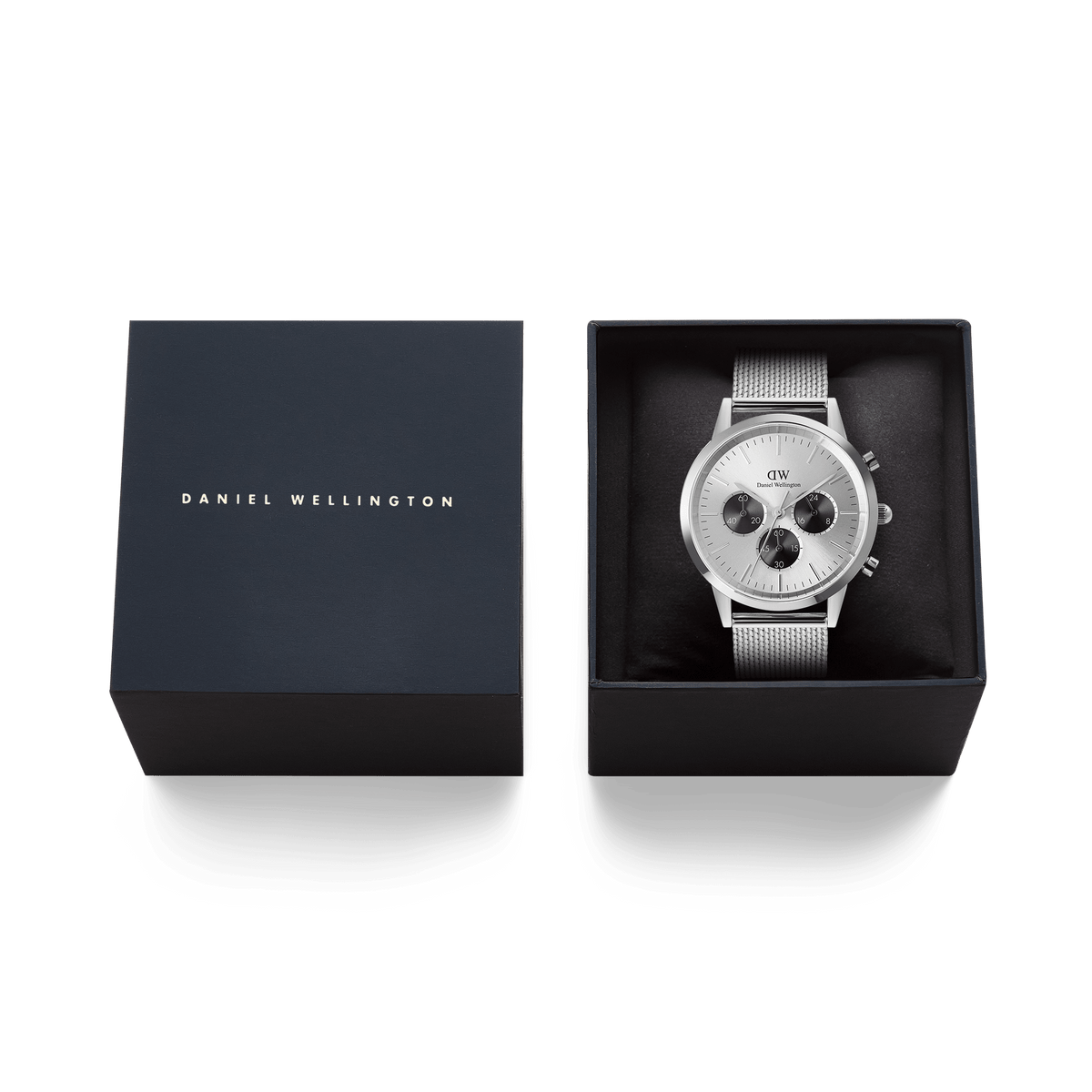Daniel Wellingtonのネイビーカラーのブランドボックスに収められたIconic Chronograph Mesh Silverのギフトパッケージです。箱の蓋にはブランドロゴが箔押しされ、ブラックのクッショニングの上にシルバーメッシュベルトのクロノグラフ時計が丁寧にセットされています。