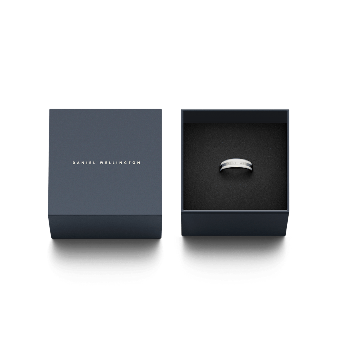 Daniel WellingtonのEmalie Ring Silverが、ネイビーのブランド専用ギフトボックスに収められています。箱の蓋にはブランドロゴが箔押しされ、ブラックのクッション上にリングが丁寧にセットされており、贈り物にぴったりの上品なパッケージです。