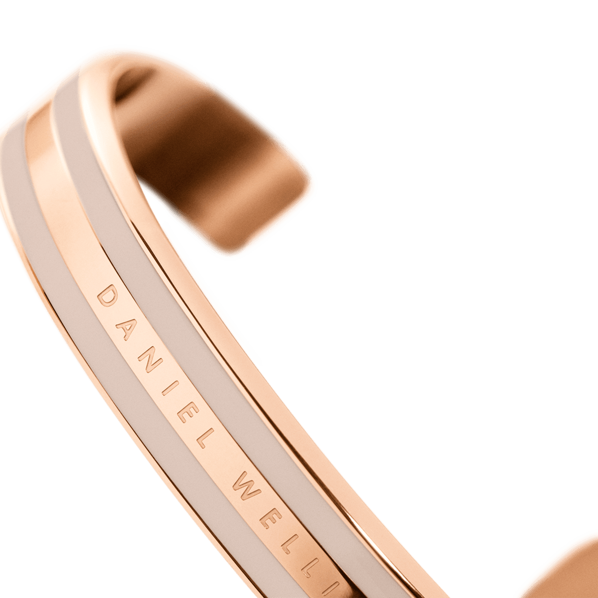 Emalie Bracelet Desert Sand Rose Goldを斜めから捉えたディテール画像です。ローズゴールドのフレームに挟まれたデザートサンドカラーのエナメルの質感や、内側に刻印されたDaniel Wellingtonのロゴが確認できます。