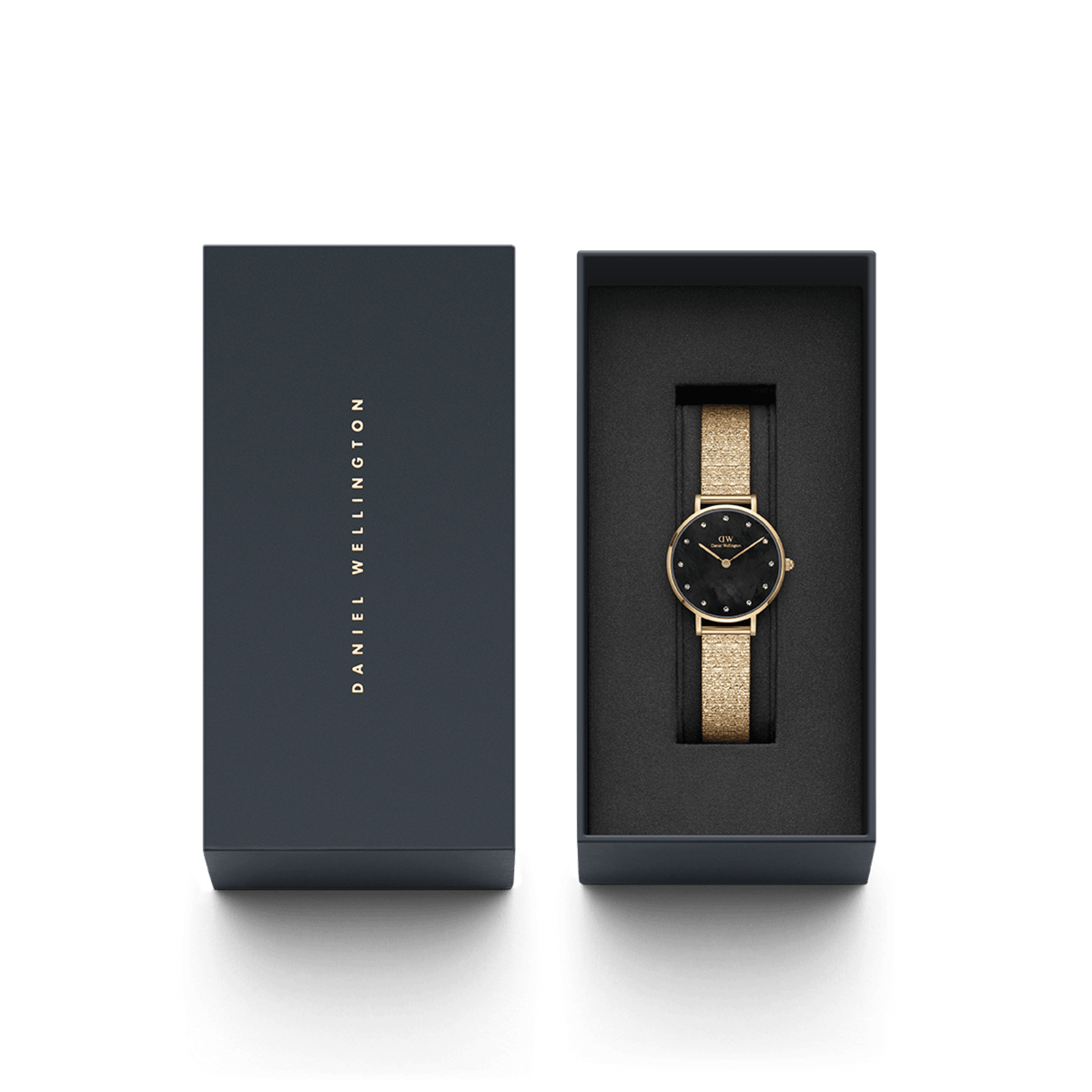 Petite Lumine Pressed Piano Black MoP Goldがダークネイビーのブランドギフトボックスに収められた様子です。箱の蓋にはDaniel Wellingtonのロゴがゴールドで刻印されており、贈り物にぴったりの上品なパッケージです。