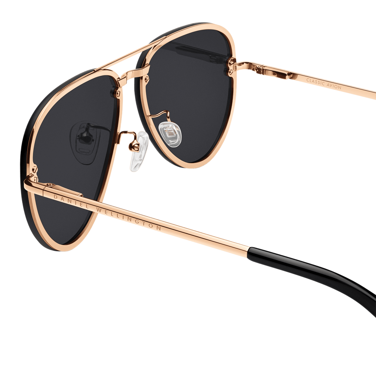 Avion Steel Rose Goldの裏面をクローズアップした画像です。ローズゴールドのブリッジ部分にはDaniel Wellingtonの刻印が施され、調節可能なクリアシリコン製ノーズパッドやテンプル内側のClassic Avionの刻印など、細部まで丁寧な仕上げが確認できます。