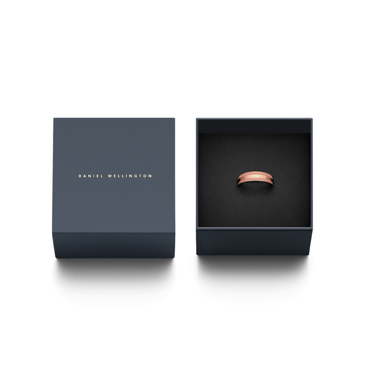 Emalie Ring Dusty Rose Rose Goldがダークネイビーの専用ギフトボックスに収められています。箱の蓋にはDaniel Wellingtonのロゴがゴールドで箔押しされており、贈り物にぴったりの上品な仕上がりです。