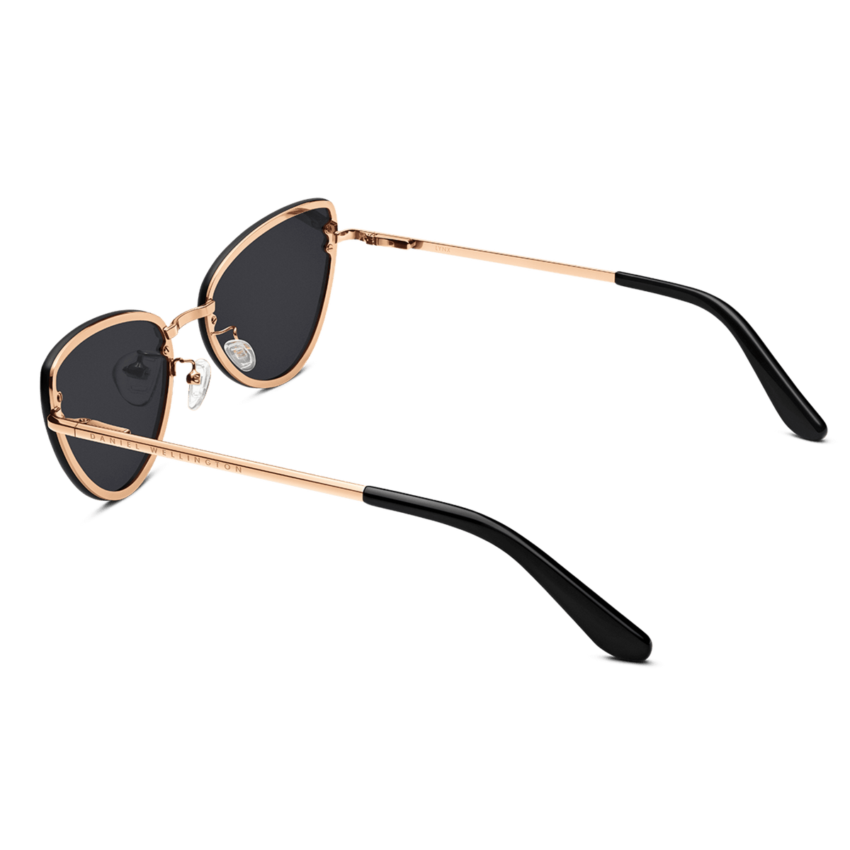 Daniel Wellington Lynx Steel Blackを斜め後方から撮影した画像です。ローズゴールドのフレームが描くキャットアイレンズの曲線や、クリアなシリコン製ノーズパッド、ブラックのテンプルチップまで続くテンプルのフォルムが確認できます。