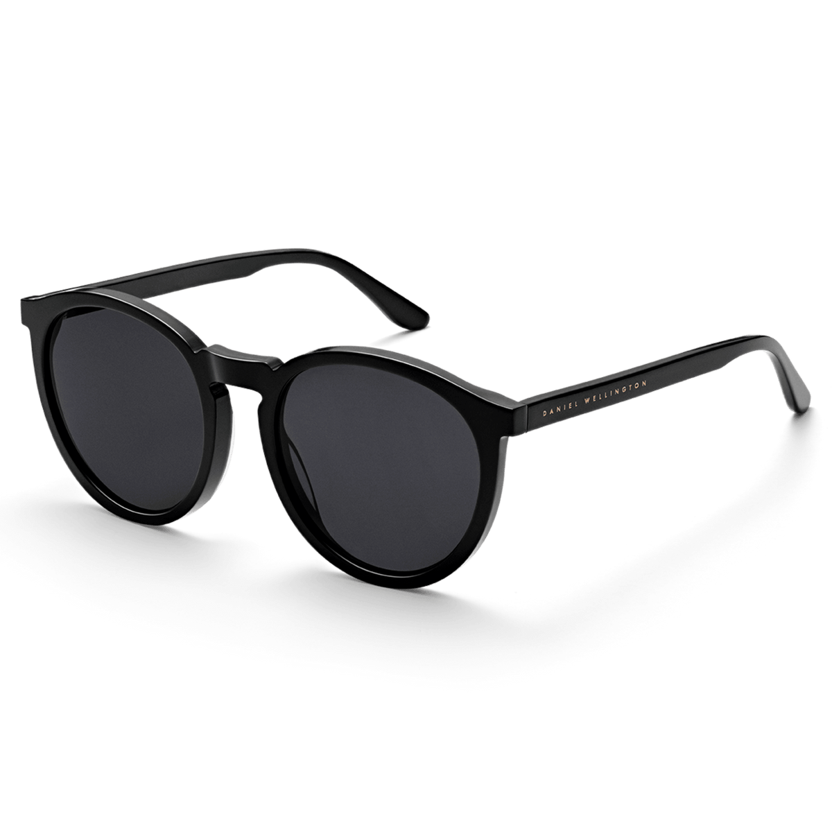 Arch Bio-Acetate Blackサングラスを斜め前方から捉えた画像です。ブラックのラウンドフレームが描く柔らかな曲線と、テンプルに刻印されたゴールドのDaniel Wellingtonロゴが確認できます。