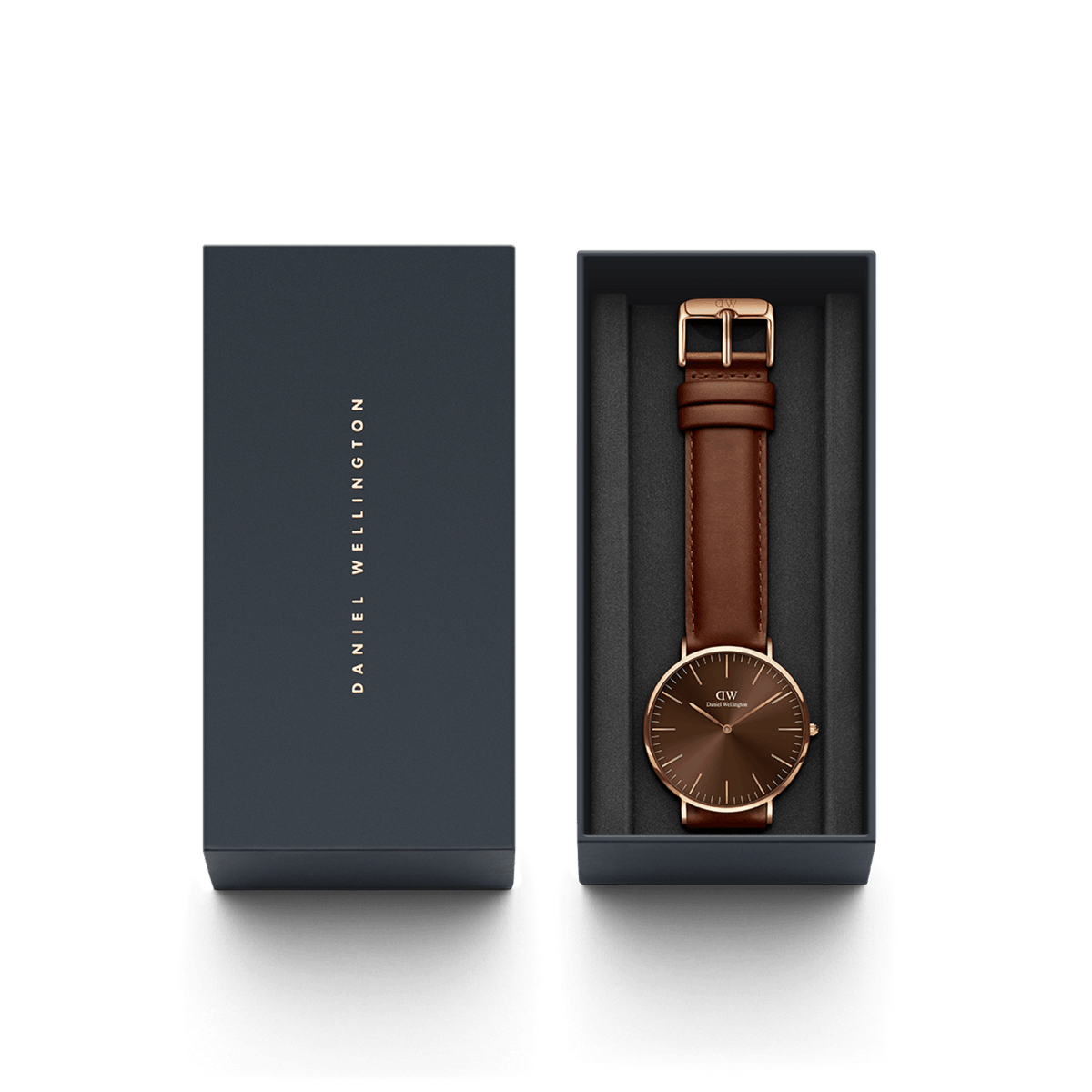 Classic St Mawes Amber Rose Goldをネイビーのギフトボックスに収めたパッケージ画像です。箔押しのブランドロゴが施された蓋と、アンバーの文字盤にブラウンのレザーストラップを合わせた本体が、整然と並んでいます。