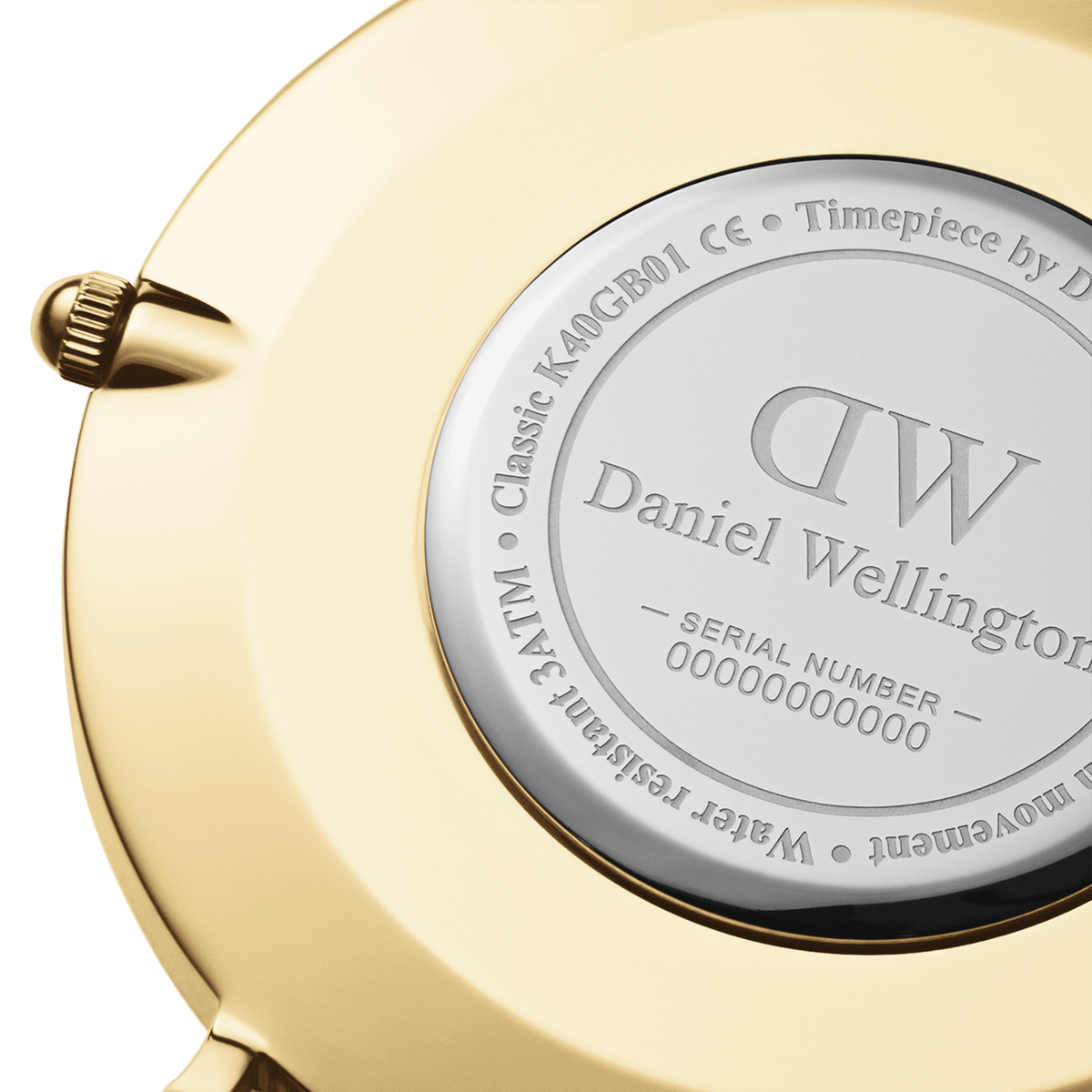 Classic St Mawesのケース裏蓋をクローズアップした画像です。ゴールドPVDメッキのケースにはDaniel Wellingtonのロゴやシリアルナンバー、3ATM防水の表記が刻印されており、リューズの細部までご確認いただけます。