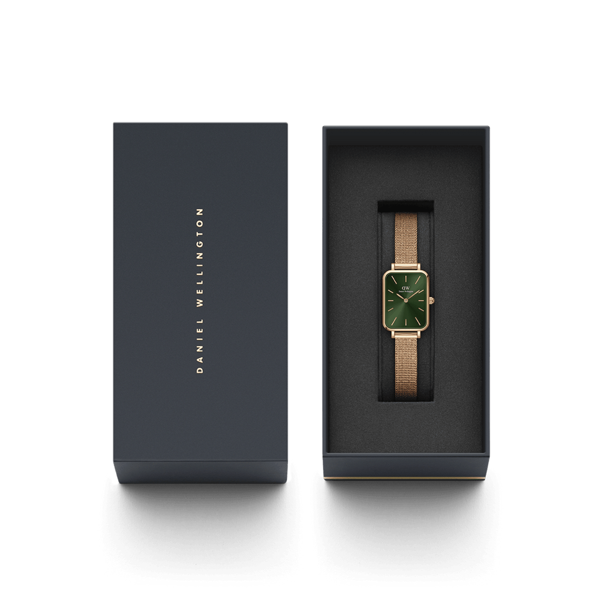 Quadro Pressed Melrose Emeraldがダークネイビーのギフトボックスに収められています。箱の蓋にはDaniel Wellingtonのロゴが金色で刻印され、内側のブラッククッションの上にエメラルドグリーンの文字盤とローズゴールドのメッシュストラップが美しく映えます。贈り物にぴったりの上品なパッケージです。