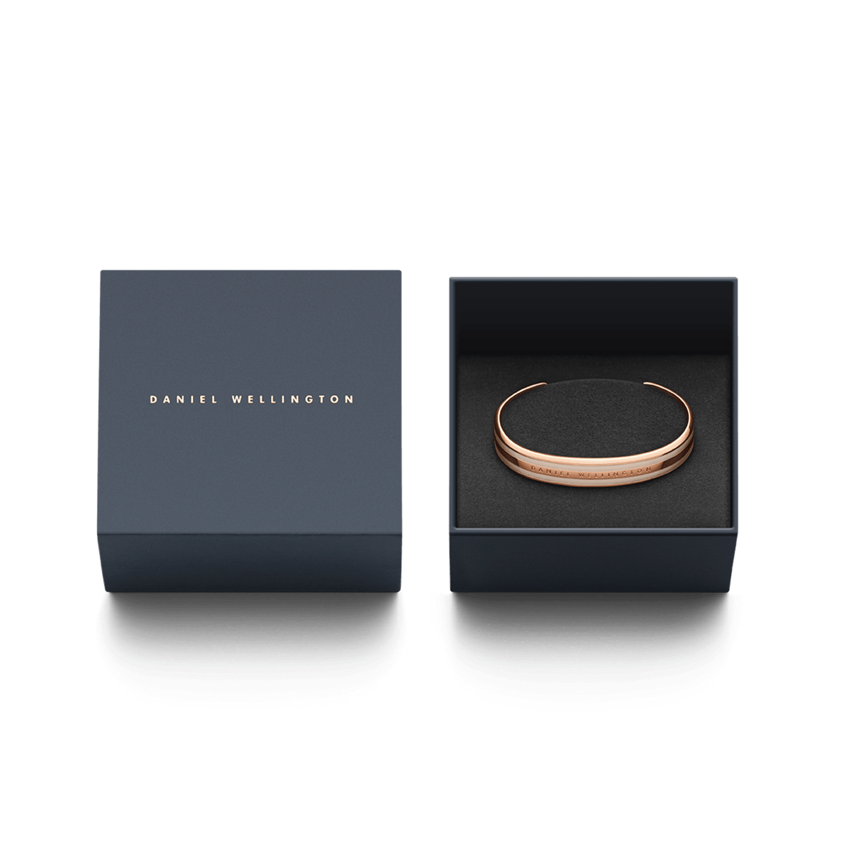 Emalie BraceletのDesert Sand Rose Goldとダークネイビーのギフトボックスを並べた画像です。箔押しされたブランドロゴがあしらわれた蓋の横には、黒いクッションケースにブレスレットが収められており、贈り物にぴったりの上品なパッケージです。