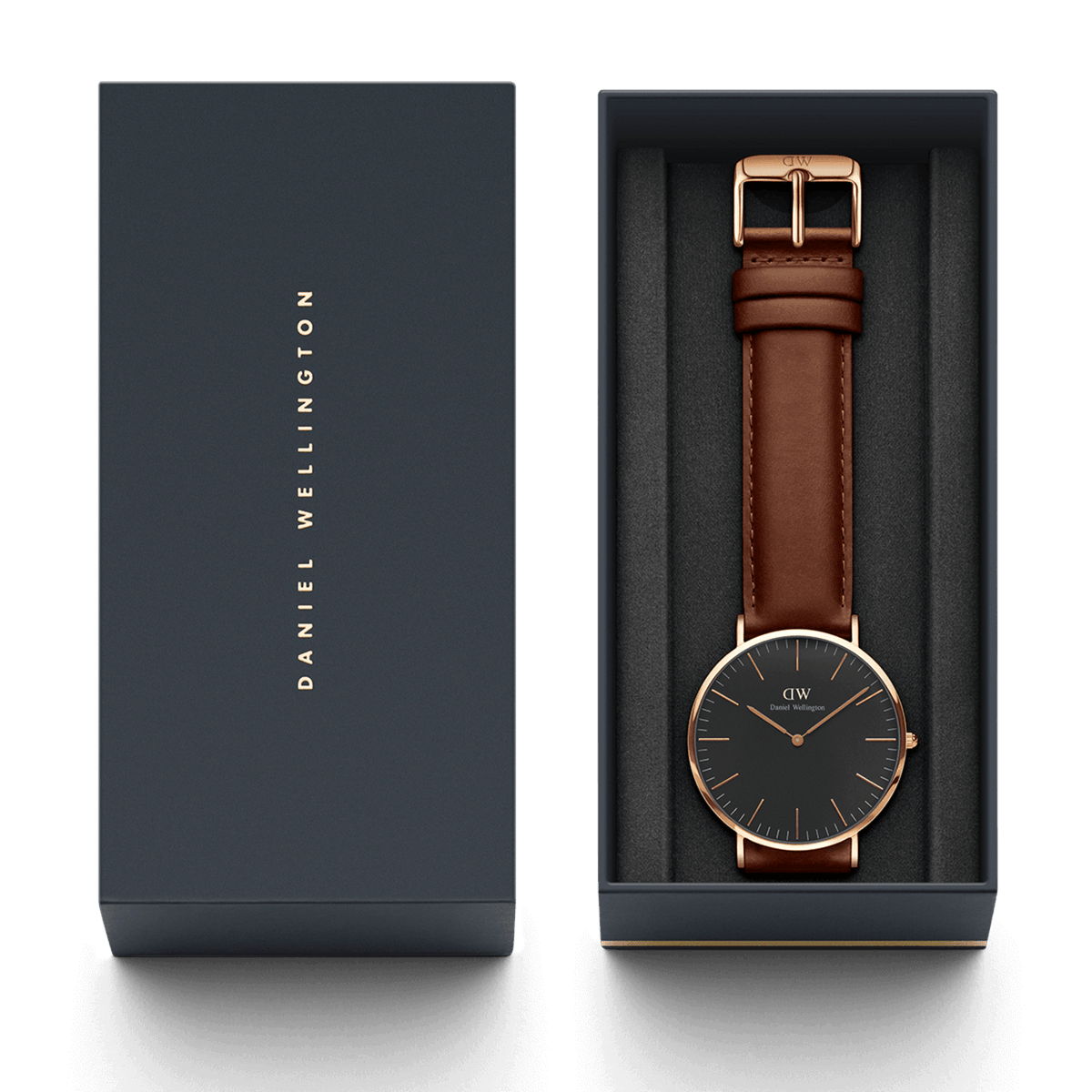 クラシック St Mawes Black Rose Goldが、ダークネイビーの専用ギフトボックスに収められた状態です。ブラックの文字盤とダークブラウンのレザーストラップをあしらった腕時計は、起毛素材のインナーに丁寧にセットされ、贈り物にぴったりの上品なパッケージングとなっています。