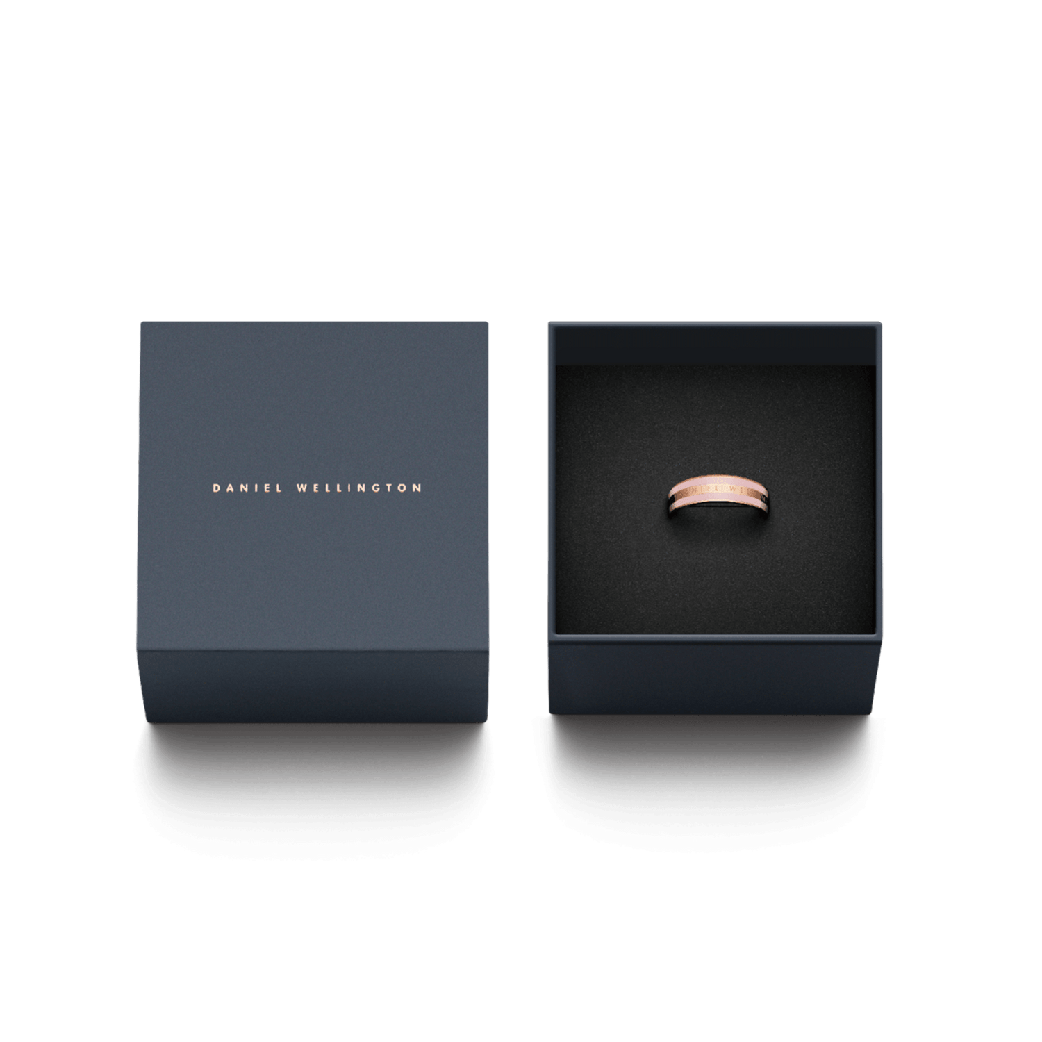 Emalie Ring Cherry Blossomが、ダークネイビーのDaniel Wellington専用ギフトボックスに収められています。蓋にはローズゴールドのブランドロゴが箔押しされ、黒いクッションの上に桜色エナメルのリングが丁寧にセットされております。