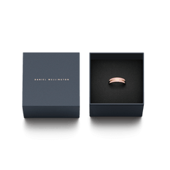 Emalie Ring Cherry Blossomが、ダークネイビーのDaniel Wellington専用ギフトボックスに収められています。蓋にはローズゴールドのブランドロゴが箔押しされ、黒いクッションの上に桜色エナメルのリングが丁寧にセットされております。