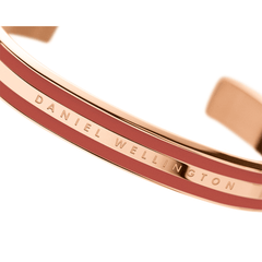 Emalie Bracelet Cherry Blush Rose Goldのクローズアップ画像です。ローズゴールドのポリッシュ仕上げとチェリーブラッシュのエナメルラインのコントラストが美しく、中央にはDaniel Wellingtonのブランドロゴが刻印されています。