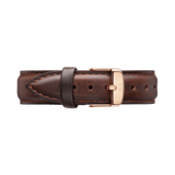Daniel WellingtonのBristol Strap ローズゴールドを折りたたんだ状態で撮影した画像です。ダークブラウンのレザーストラップは、きめ細かな革の質感と両サイドに施された丁寧なステッチが特徴で、中央に配されたローズゴールドのピンバックルとのバランスが美しい仕上がりとなっています。