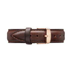 Daniel WellingtonのBristol Strap ローズゴールドを折りたたんだ状態で撮影した画像です。ダークブラウンのレザーストラップは、きめ細かな革の質感と両サイドに施された丁寧なステッチが特徴で、中央に配されたローズゴールドのピンバックルとのバランスが美しい仕上がりとなっています。