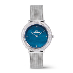 ダニエルウェリントンのCrystalline Bezel Sterling Blueです。ブルーマザーオブパールの文字盤にクリスタルベゼルが輝き、シルバーメッシュストラップをあしらった32mmのレディース腕時計を正面から撮影しています。